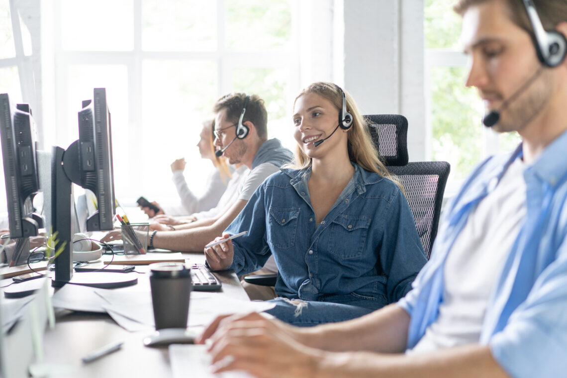 Contact center support phone operator with headset working in call center